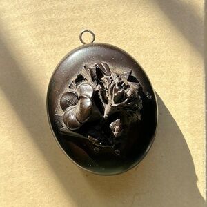 antique Victorian vulcanite mourning locket pendant with a carved floral design